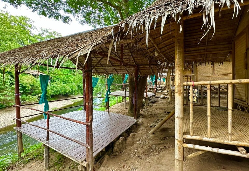 บรรยากาศลานกางเต็นท์และพื้นที่ส่วนกลางริมน้ำของ ติดใจ โฮมสเตย์ สวนผึ้ง ราชบุรี