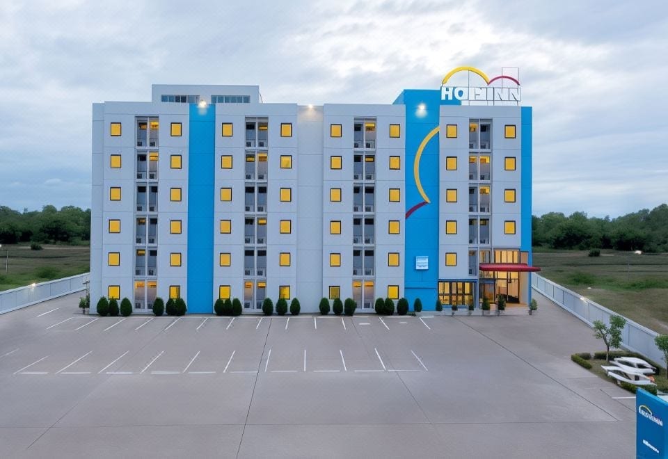 ห้องพักมาตรฐานของ Hop Inn Rayong ตกแต่งเรียบโทนสว่าง เตียงคู่และโต๊ะข้างเตียง