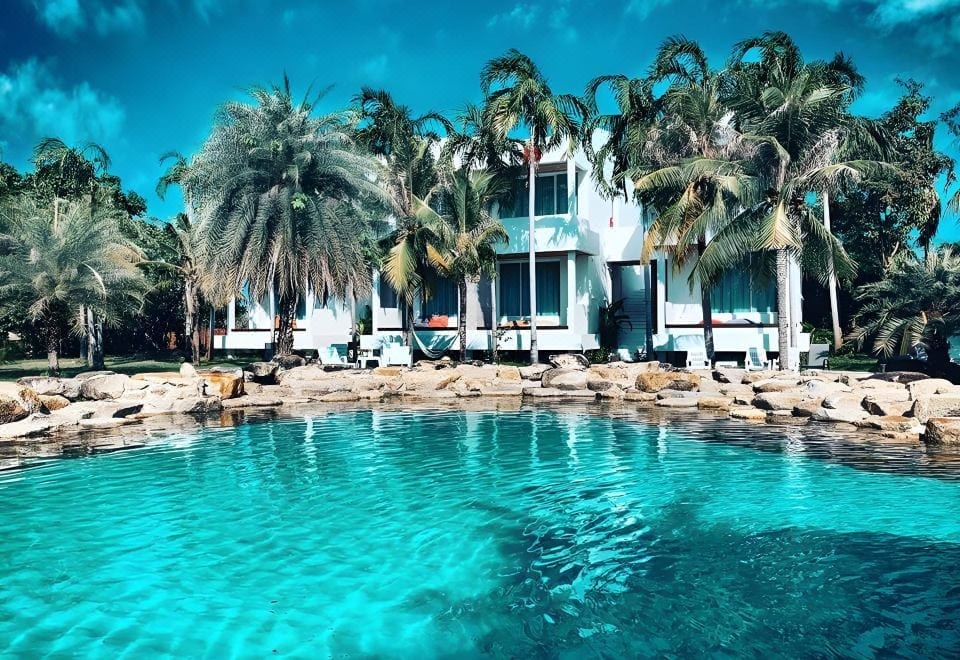 สระว่ายน้ำของ Ohana Resort ระยอง สระน้ำทะเลพื้นทรายขาวเลียนแบบชายหาดท่ามกลางต้นมะพร้าว
