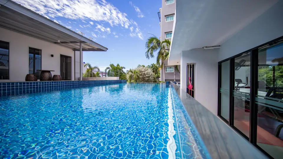สระว่ายน้ำกลางแจ้งของ Phavina Serviced Residence Rayong พร้อมพื้นที่นั่งเล่นริมสระ