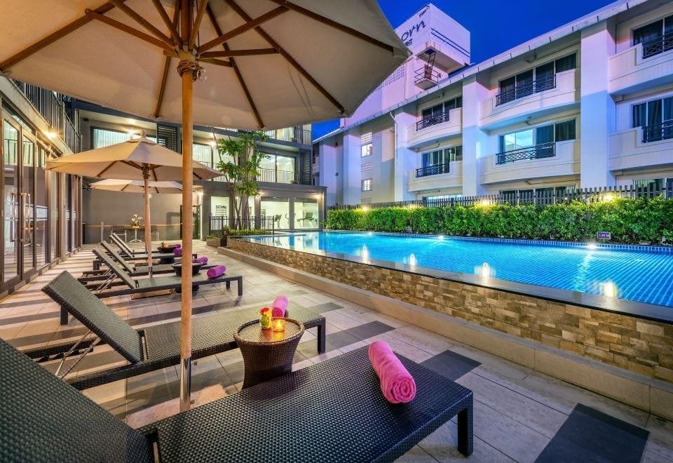 สระว่ายน้ำกลางแจ้งของ PLAAI Prime Hotel Rayong พร้อมพื้นที่นั่งเล่นริมสระ
