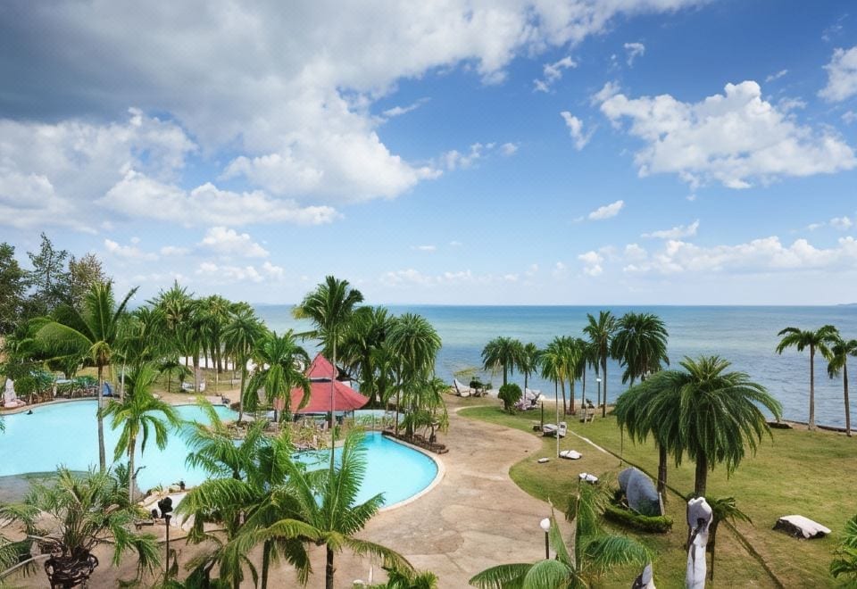 สระว่ายน้ำกลางแจ้งพร้อมสไลเดอร์ของ Rockgarden Beach Resort ระยอง ท่ามกลางสวนเขียว