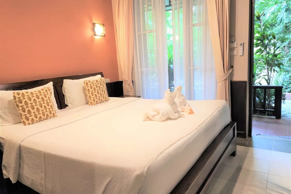 ห้องพักของ Samed Villa Resort ตกแต่งสไตล์ไทยร่วมสมัย เตียงใหญ่และระเบียงส่วนตัวมองออกสวน