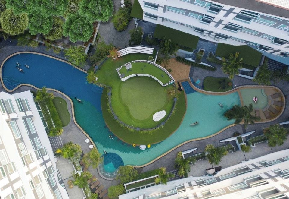 สระว่ายน้ำกลางแจ้งระบบน้ำเกลือของ Wisdom Hotel & Residence ระยอง พร้อมเก้าอี้อาบแดดริมสระ