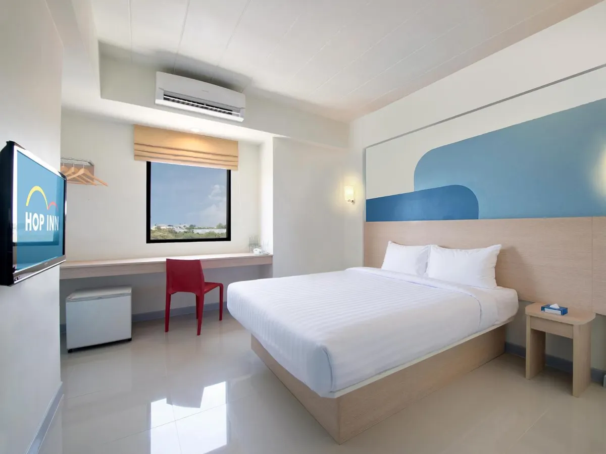 ห้องพักของ Hop Inn ร้อยเอ็ด ดีไซน์มินิมอล เตียงคู่ ผนังสีอุ่น พร้อมโต๊ะทำงาน
