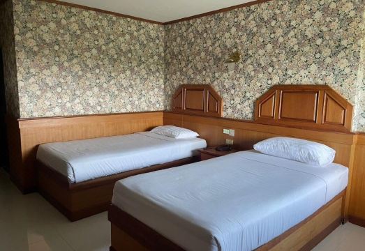 ห้องพักของ Sakol Grand Palace Hotel สกลนคร เตียงใหญ่ โทนสีอบอุ่น พร้อมทีวีและเครื่องปรับอากาศ