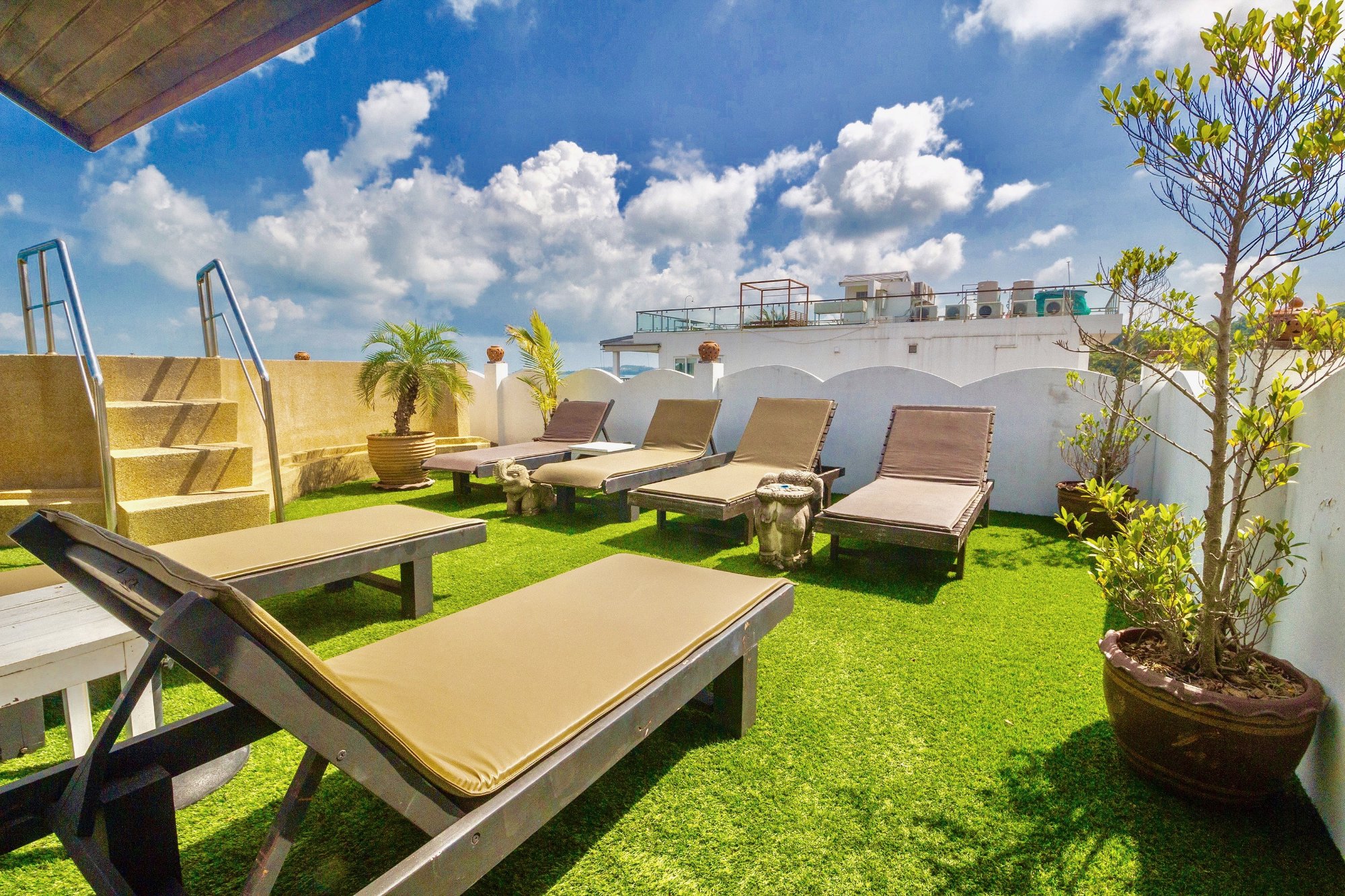 The rooftop solarium and sun loungers at Hacienda Fisherman's Village, with a lawn and views over Bophut bay
