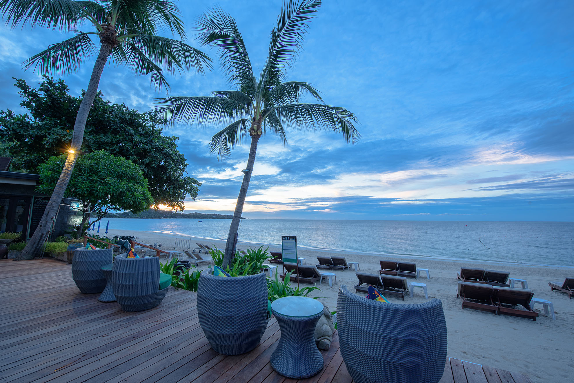 The poolside area at Samui Jasmine Resort with sun loungers looking out to the sea