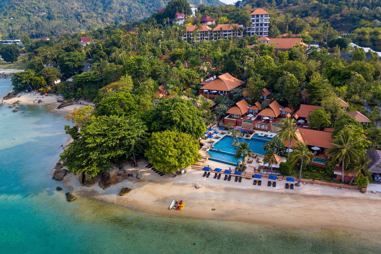 Aerial view of Renaissance Koh Samui on its private bay at the north end of Lamai, showing orange-roofed buildings, the pool and a small sandy cove