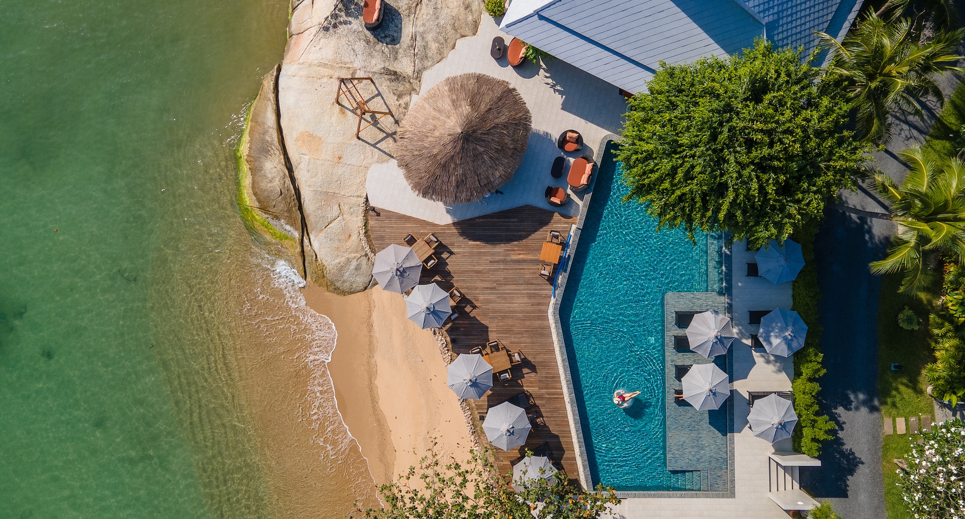 มุมพักผ่อนริมทะเลของ Rocky's Boutique Resort ท่ามกลางโขดหินและสวนเขตร้อน