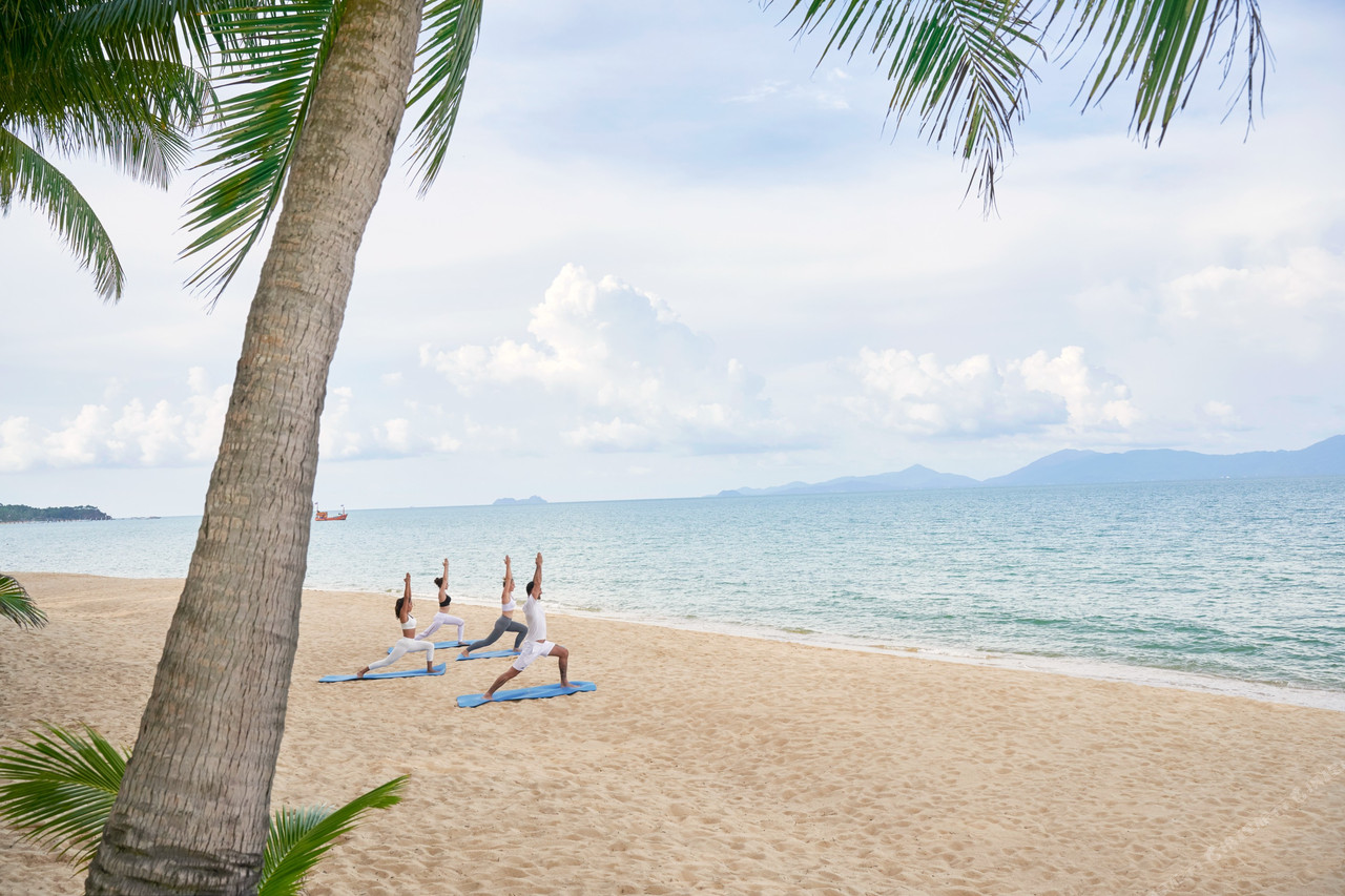 คลาสโยคะยามเช้าริมหาดแม่น้ำของ Santiburi Koh Samui ใต้ทิวมะพร้าว มองเห็นทะเลและเกาะพะงันเป็นฉากหลัง