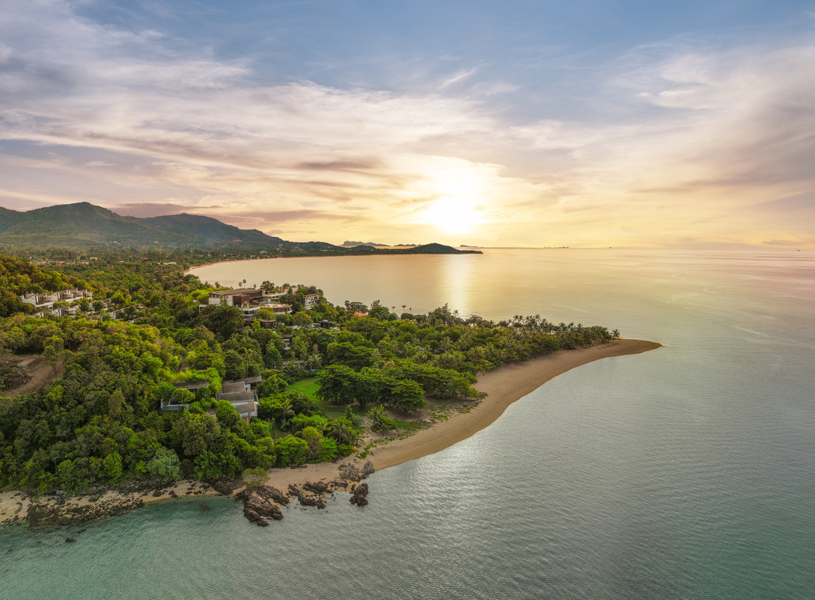 ภาพมุมสูงของ W Koh Samui บนหัวแหลมป่าเขียวริมหาดแม่น้ำ เกาะสมุย ยามพระอาทิตย์ตก