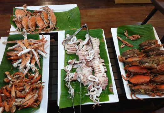 ระเบียงไม้ริมคลองอัมพวาของ At Casa Guesthouse สำหรับนั่งชมเรือผ่าน