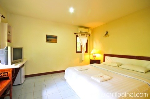 ระเบียงหน้าบ้านพักของบ้านครูปูพร้อมเก้าอี้นั่งเล่นในสวน