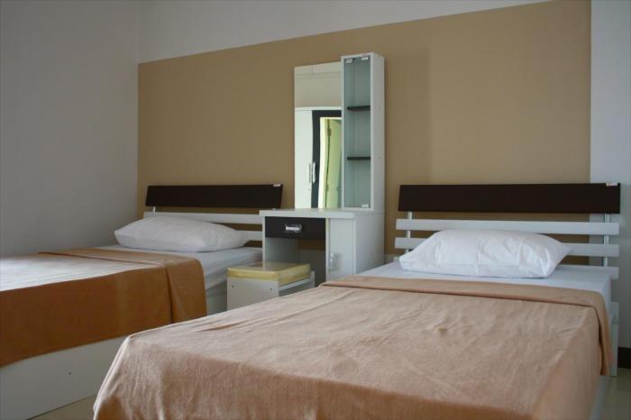 ห้องพักของ Baanbudsarin Apartment สิงห์บุรี มีเตียงนอน แอร์ และมุมนั่งเล่น