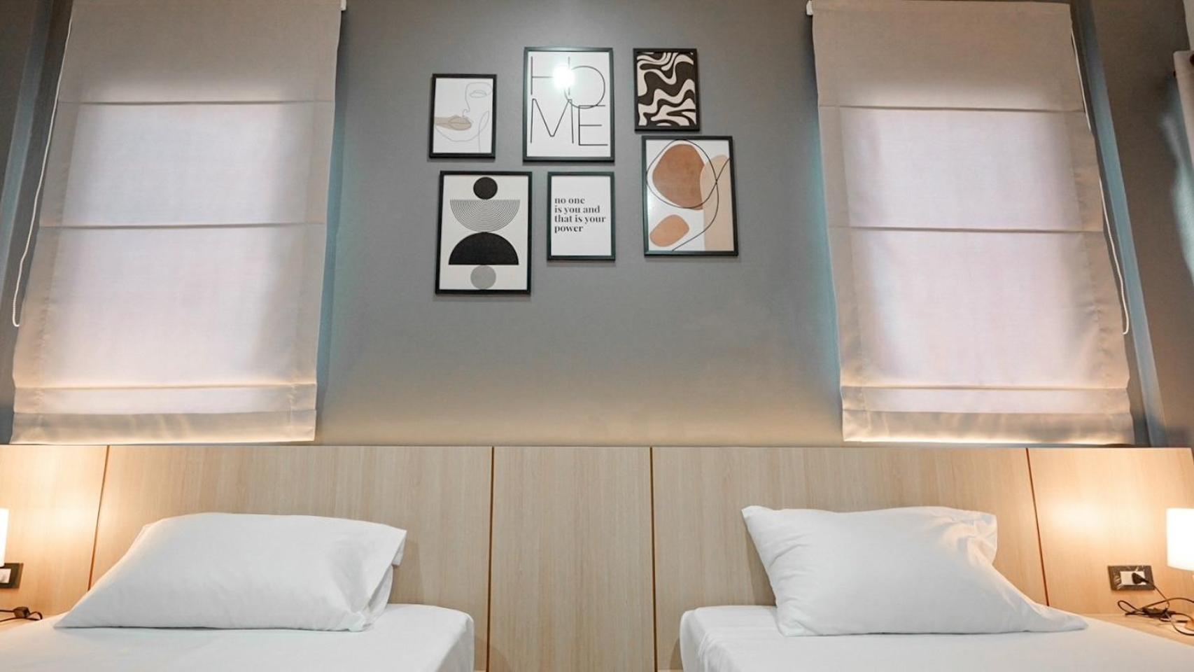 ห้องพักของ Boonsiri Boutique Hotel ศรีสะเกษ ตกแต่งโทนสีชมพูอ่อน เตียงนุ่ม ทีวีจอแบนและตู้เย็น