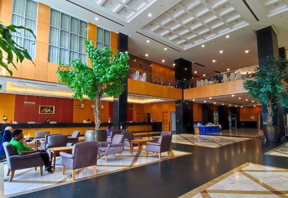 ล็อบบี้ขนาดใหญ่ของ Diamond Plaza Hotel เคาน์เตอร์ต้อนรับยาว โซฟานั่งพักและต้นไม้ใหญ่