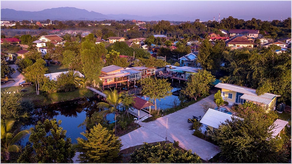 บรรยากาศสวนและบ้านพักทรงคอทเทจของ BanRai ChernMa Resort เมืองตาก ท่ามกลางต้นไม้เขียว
