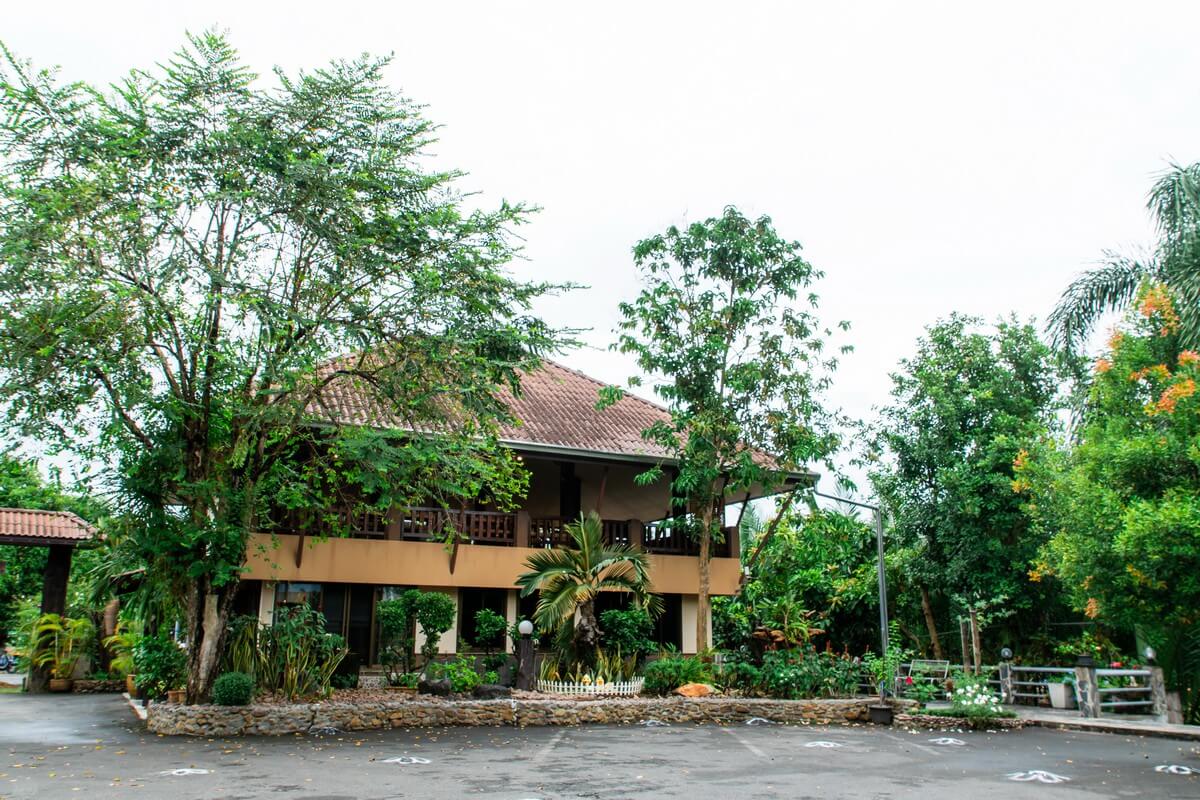 ห้องพักบ้านไม้ไทยของ BaanRimNam Resort Trat ตกแต่งโทนอบอุ่นพร้อมเตียงนุ่มและเดย์เบดริมหน้าต่าง
