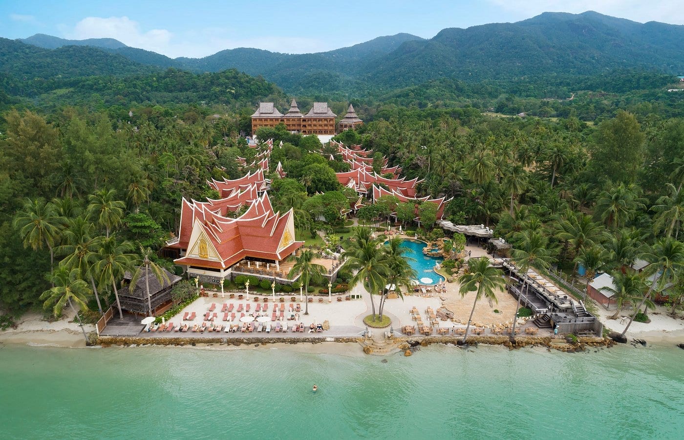 สระว่ายน้ำกลางแจ้งของ Santhiya Tree Koh Chang ล้อมรอบด้วยอาคารไม้สักและต้นไม้เขียวครึ้ม