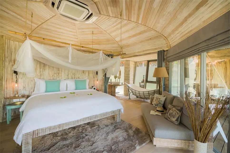 A two-storey treehouse villa in the forest at TreeHouse Villas Koh Yao, reached across a suspension bridge