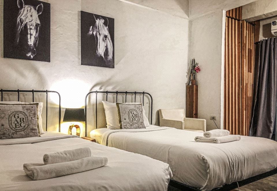 มุมสระว่ายน้ำกลางแจ้งในคอร์ตยาร์ดของ De Lit Hotel อุบลราชธานี ผนังปูนเปลือยโทนขาว-น้ำเงิน