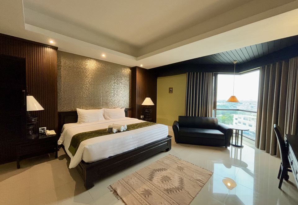 ห้องพักอีกแบบของ Napalai Hotel พร้อมเตียงและพื้นที่นั่งเล่น