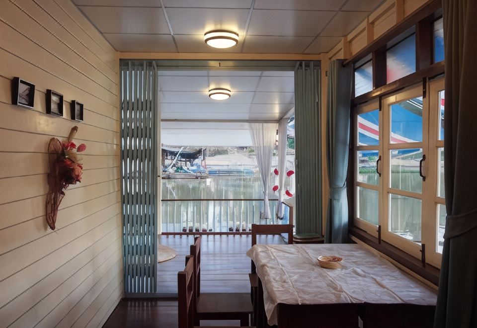 ระเบียงและส่วนนั่งเล่นริมแม่น้ำของเรือนแพ PaeStay อุทัยธานี